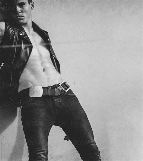 View Posemale Model Dressed In A Black Leather Vest Leaning Against