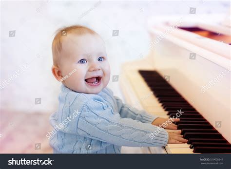 Cute Laughing Baby Playing The Piano Stock Photo 519005641