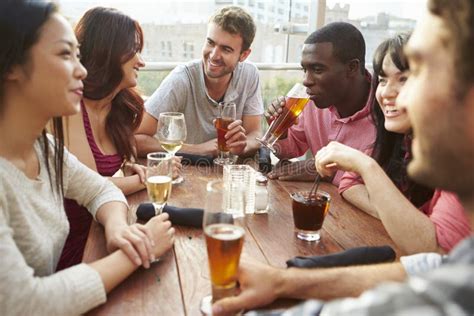 Group Of Friends Enjoying Drink At Outdoor Rooftop Bar Stock Image