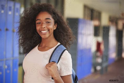 Feliz Adolescente Negro Sonriendo En El Pasillo De La Escuela Foto De