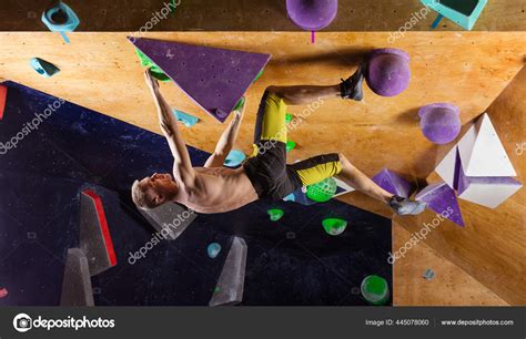 Young Man Bouldering Indoor Climbing Gym Trying Solve Challenging