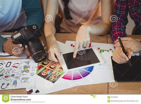 Mid Section Of Graphic Designers Interacting With Each Other While