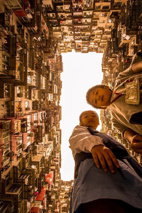 Two People Standing In Front Of A Tall Building With Lots Of Buildings