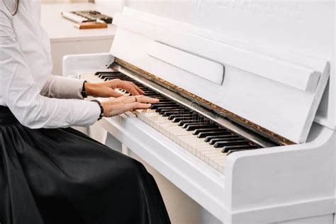 Beautiful Young Attractive Woman In Dress Playing White Piano Stock
