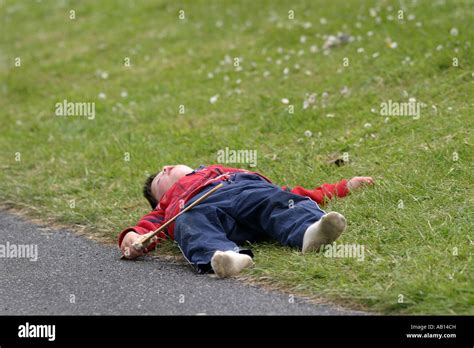 Young Boy Playing Dead Holding Wooden Sword Cornwall Uk Stock Photo Alamy