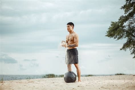 Free Photo Young Healthy Man Athlete Doing Exercise With Ball At The