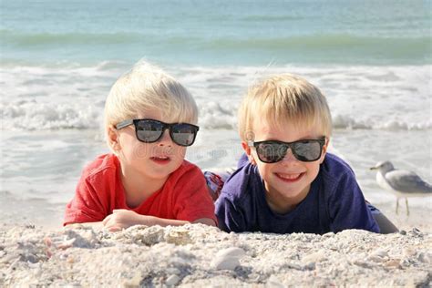 Happy Young Children Laying In The Sun On The Beach Stock Photo Image