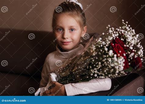 Portrait Of Cute Little Girl Holding Red Rose In Her Hands T To Her