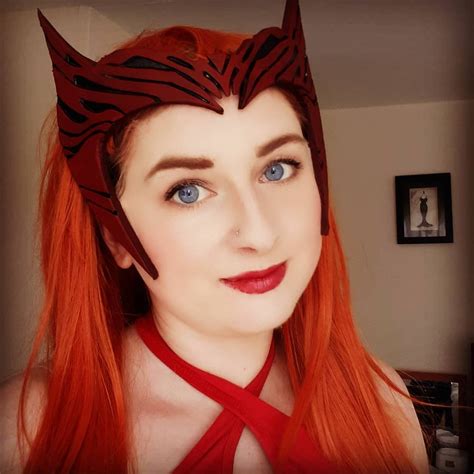 A Woman With Long Red Hair Wearing A Cat Ears Headband And Looking At