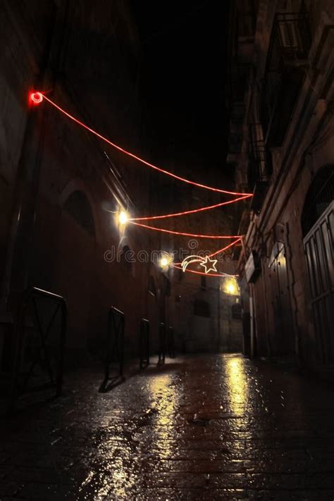 The Dark Narrow Empty Street Is Wet After The Rain With Christmas