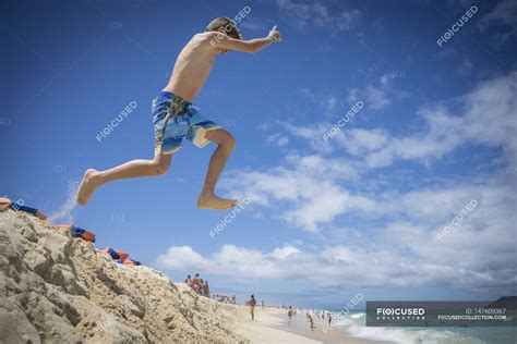Boy Jumping In Sand Dunes At Beach — Having Fun Playing Stock Photo