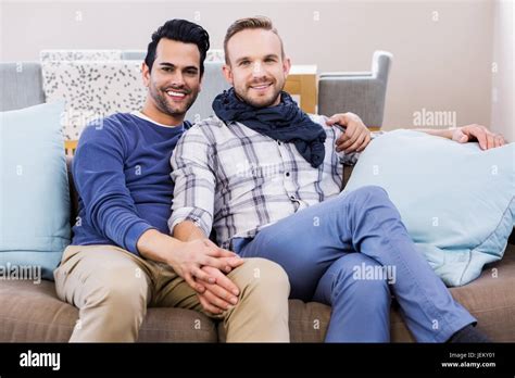 Una pareja gay tomados de las manos sobre el sofá Fotografía de stock Alamy