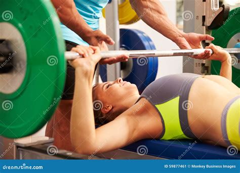 Woman Bench Pressing Weights With Assistance Of Trainer Stock Image Image Of Focus Hands