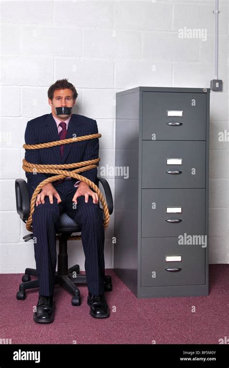 Businessman Tied To An Office Chair With Rope Look Of Fear On His Face