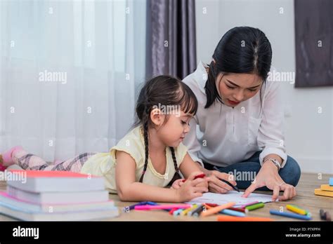 mom teaching her daughter to drawing in art class back to school and education concept