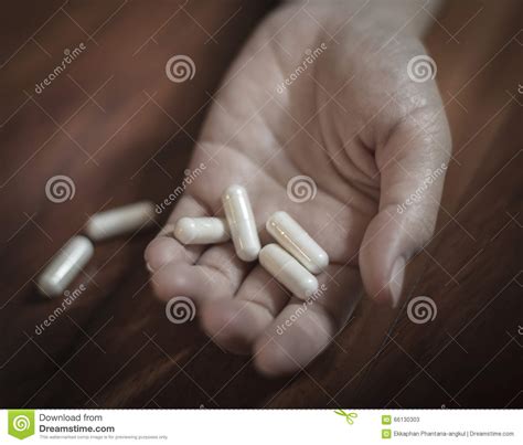 Drug Abuse Concept Passive Hand On Floor With Spilled Pills Stock