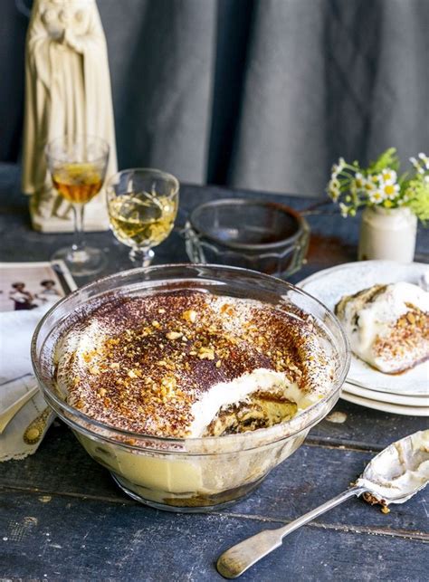 A Table Topped With Plates And Bowls Filled With Dessert Next To Wine