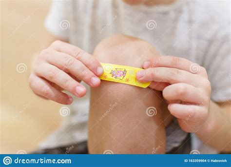 Little Boy With Adhesive Bandage On Knee Indoors Closeup Stock Photo