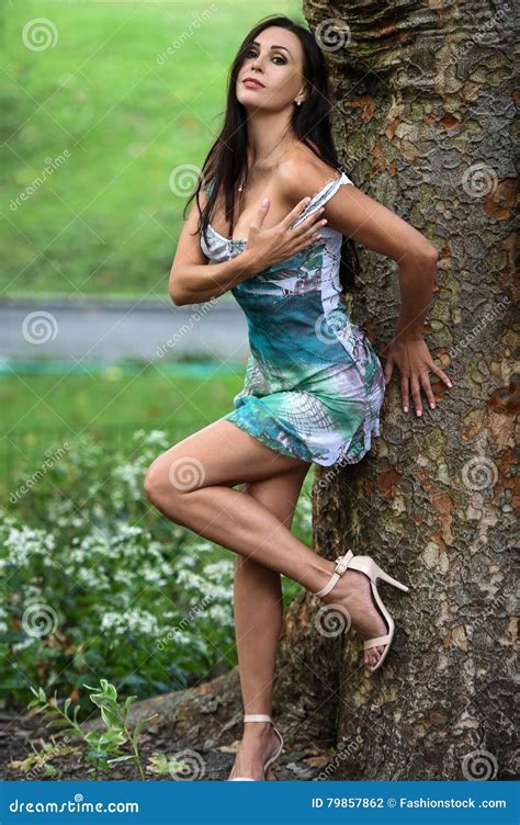 Attractive Brunette Woman Posing Outdoor In The Park Stock Photo