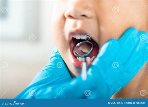 Doctor Examines Oral Cavity Of Little Child Uses Mouth Mirror To