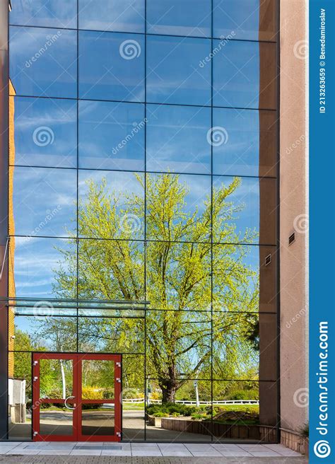 A Modern Office Building With Glass Doors And Windows Reflection In