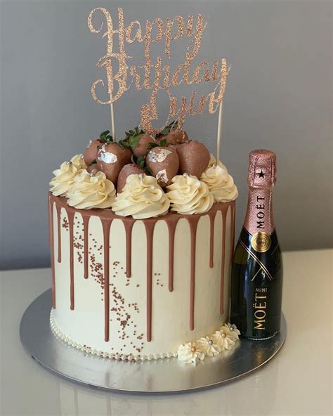 gold chocolate drip cake with strawberries pink flowers strawberry drip cake ravens bakery