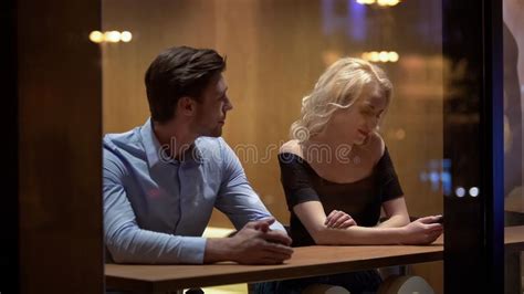Handsome Man Sitting In Restaurant And Flirting With Shy Woman