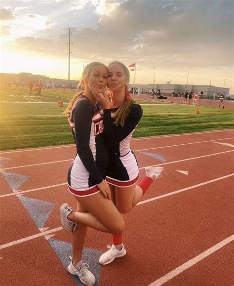 Two Cheerleaders Pose For A Photo On The Track