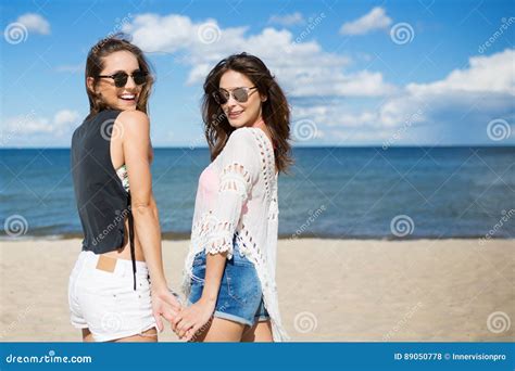 Young Happy Women Standing On Beach Holding Hands Stock Photo Image