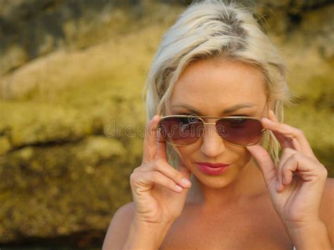 Young Attractive Happy And Cheerful Blond Girl In Bikini Smiling Playful Holding Sunglasses