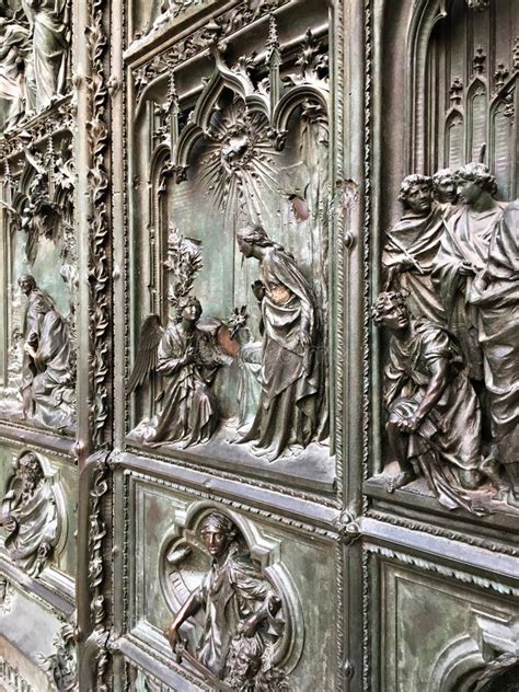 The Bas Reliefs On The Large Metal Door Of The Famous Milan Cathedral