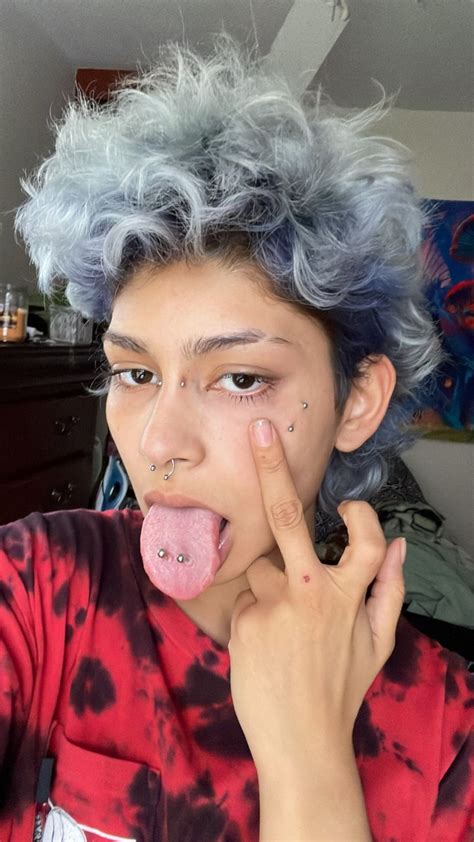 Gender Queer Person With Messy Curly Blue Hair And Piercings Tongue