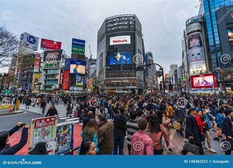 Crowds Of People Walking Across At Shibuya Famous Crossing Street In