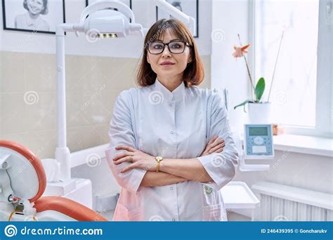 Portrait Of Smiling Mature Female Dentist Looking At Camera In Office