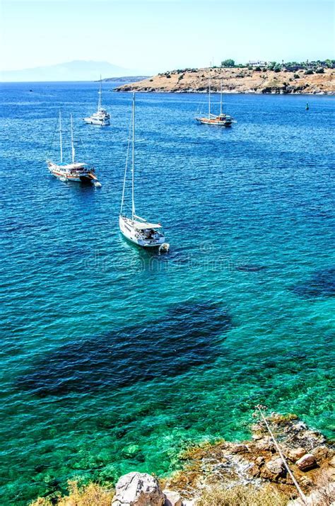 Four White Yachts In The Turquoise Waters Of The Aegean Sea In The