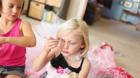 Two Young Girls Play Dress Up And Put Make Up On Themselves Stock