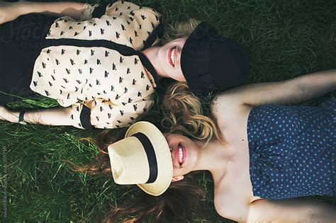 Two Female Friends Are Lying On Grass And Laughing By Jovana Rikalo Stocksy United