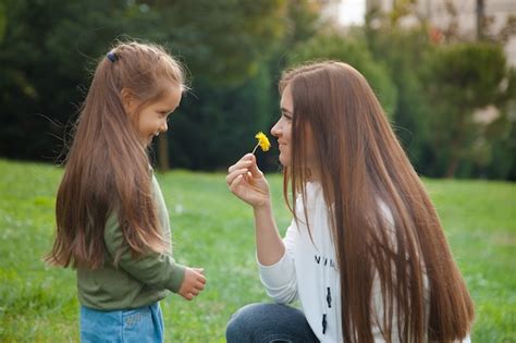 Madre E Hija En El Parque Madre Sosteniendo Una Flor De Su Hijo