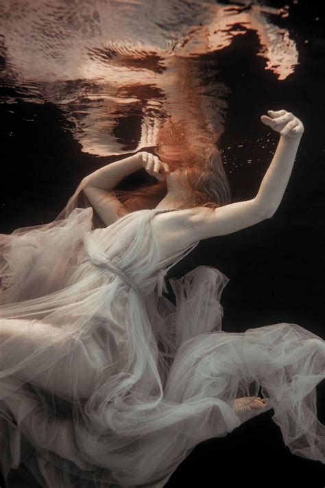 A Woman In A White Dress Floating Under Water
