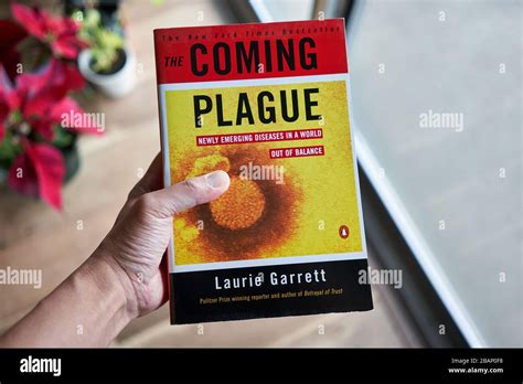 Hand Holding The Book The Coming Plague Newly Emerging Diseases In A