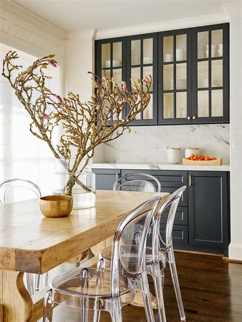 In addition to interior cabinet lighting, painting or wallpapering the back wall of cabinets with glass fronts adds a pop of bright color to kitchen cabinetry. Black Dining Room Cabinets with Glass Doors - Transitional ...