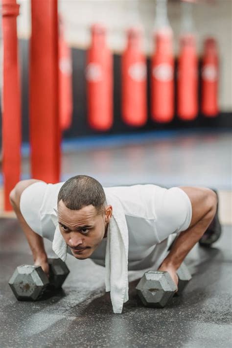 Strong Ethnic Sportsman Doing Pushing Up Exercises With Dumbbells