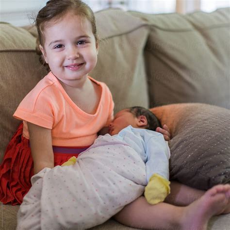 Proud Sister Holding Her Newborn Brother For The First Time By