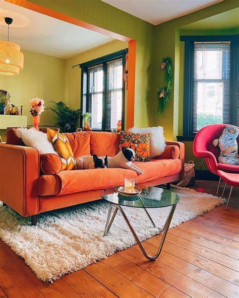 A Living Room With Orange Couches And Chairs In Front Of Two Windows On