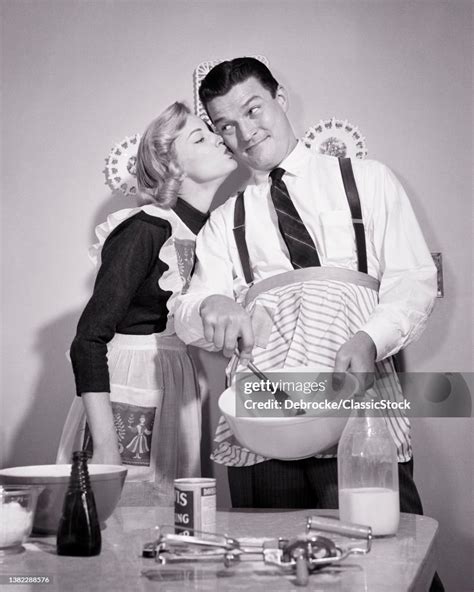 1950s Wife Kissing Her Husband On The Check As He Mixes Batter Cooks News Photo Getty Images