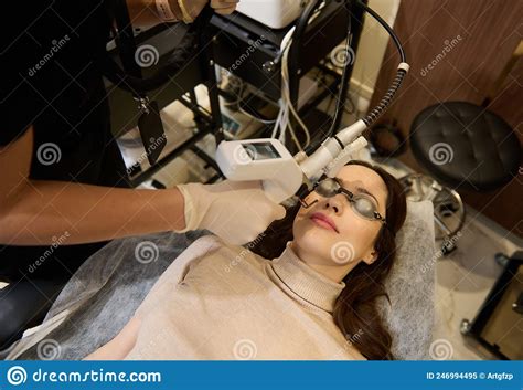 Top View Of European Woman Getting Facial Laser Polishing And