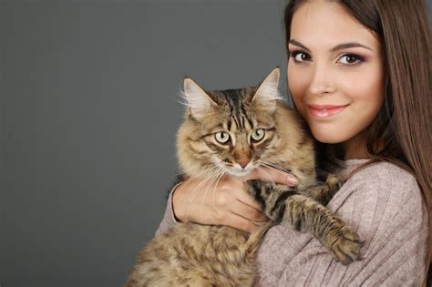 Premium Photo Beautiful Young Woman Holding Cat On Gray Background