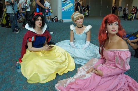 Three Women Dressed Up As Princesses Sit On The Floor In Front Of