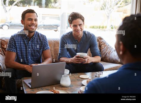 Three Male Friends Talking Over Coffee At A Coffee Shop Stock Photo Alamy