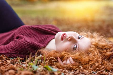 Premium Photo Red Haired Girl Lies In The Fallen Yellow Foliage
